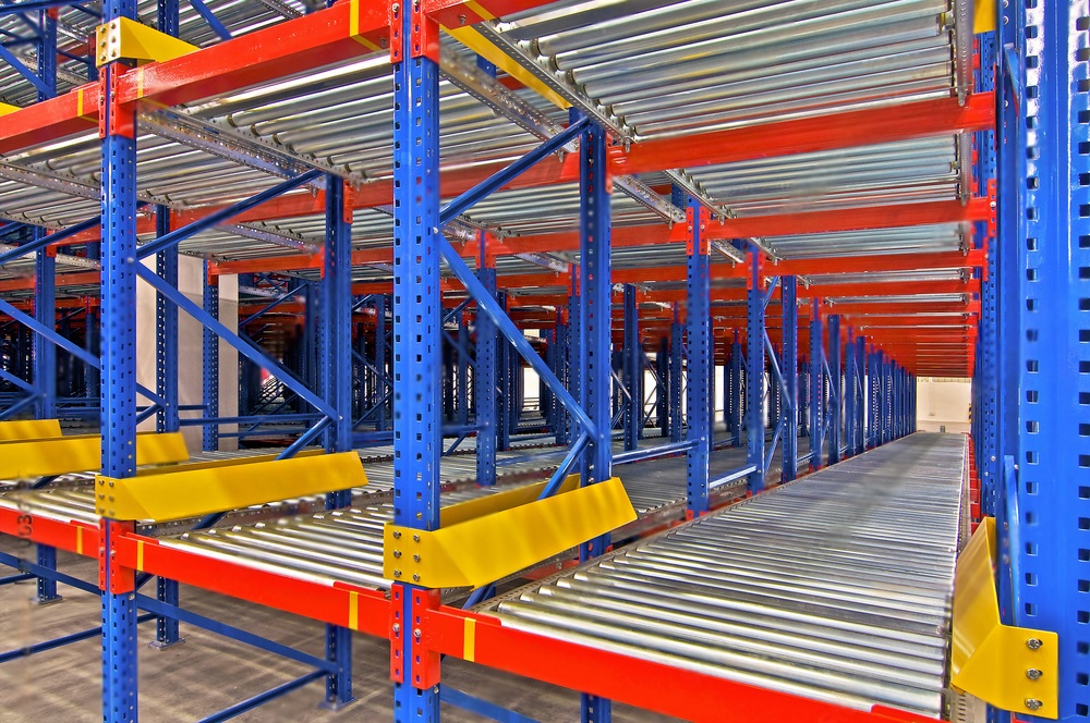  A warehouse storage system with angled rollers where pallets loaded at the back automatically slide down for efficient picking at the front (gravity flow racking).