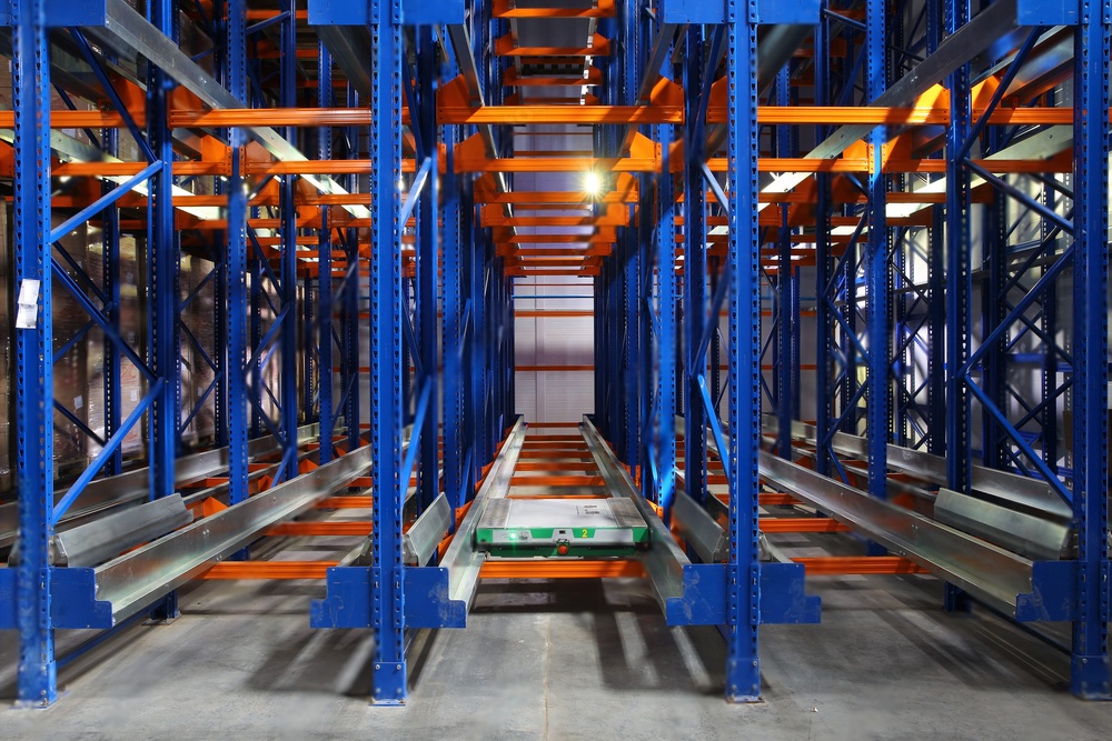 Warehouse with semi-automated shuttle racking system for high-volume storage.