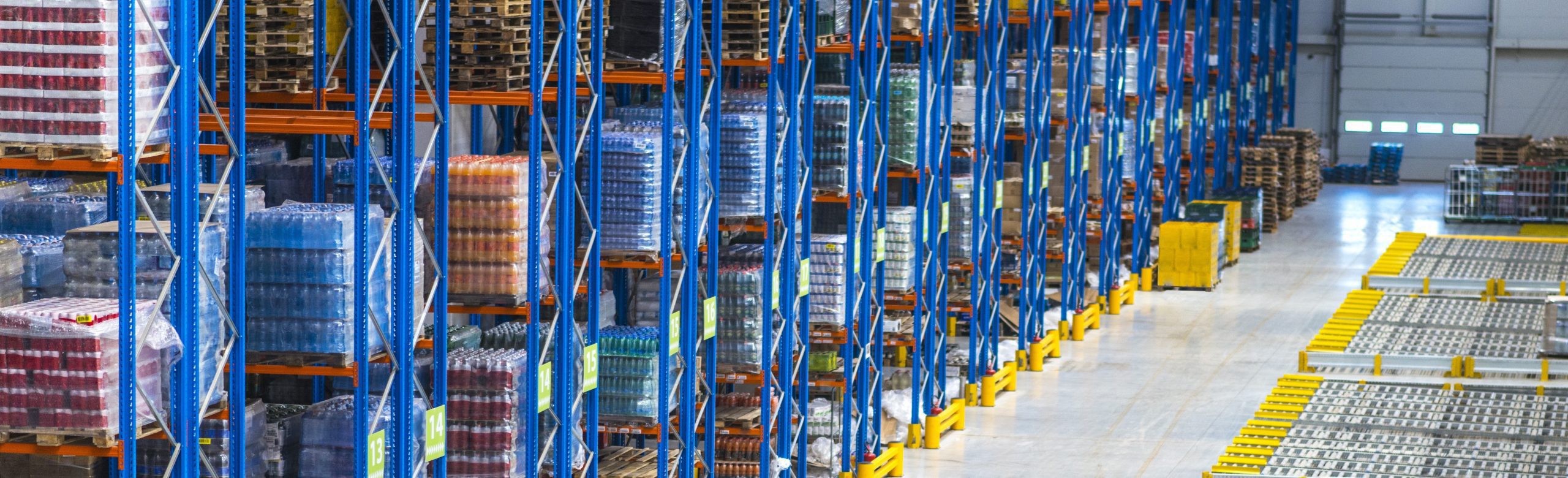 Industrial Racking System in a distribution warehouse building with large storage area and goods on shelves.