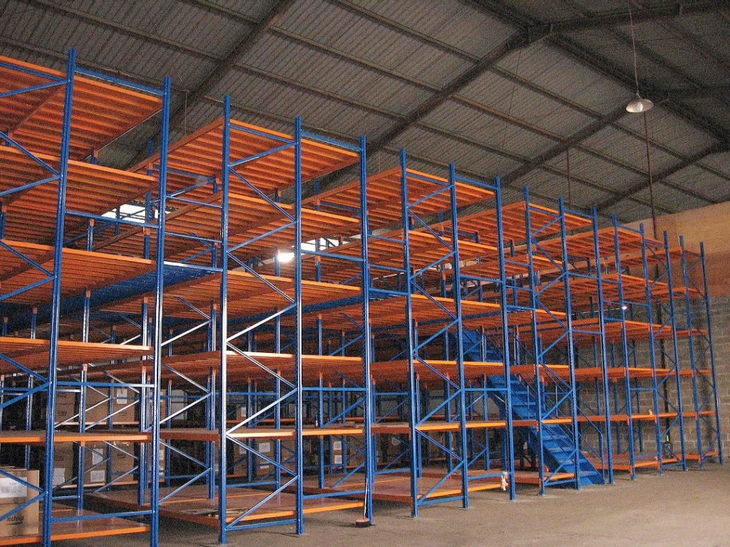 High-capacity racking platform in a warehouse, displaying stacked pallets on lower levels with an elevated work area on top.