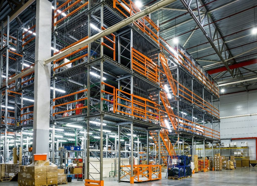 High-capacity platform in a warehouse, displaying stacked pallets on lower levels with an elevated work area on top.