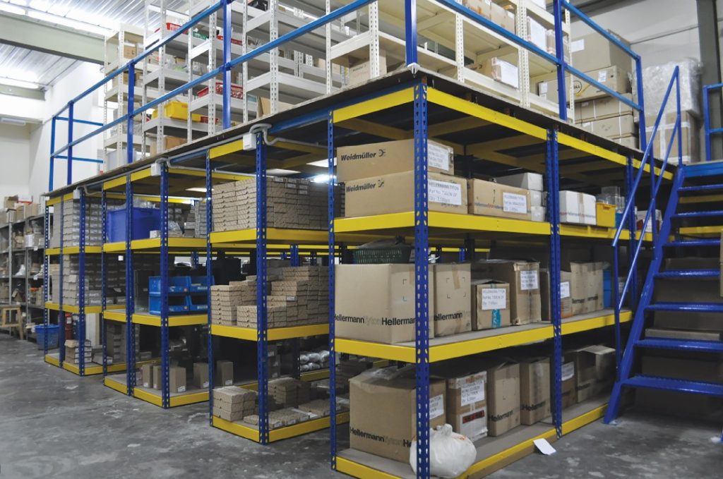 Racking supported platform in a warehouse, displaying stacked pallets on lower levels with an elevated work area on top.